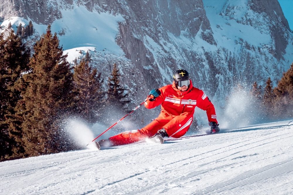 Private ski lessons in Gstaad: an instructor carving down an empty piste above Rougemont