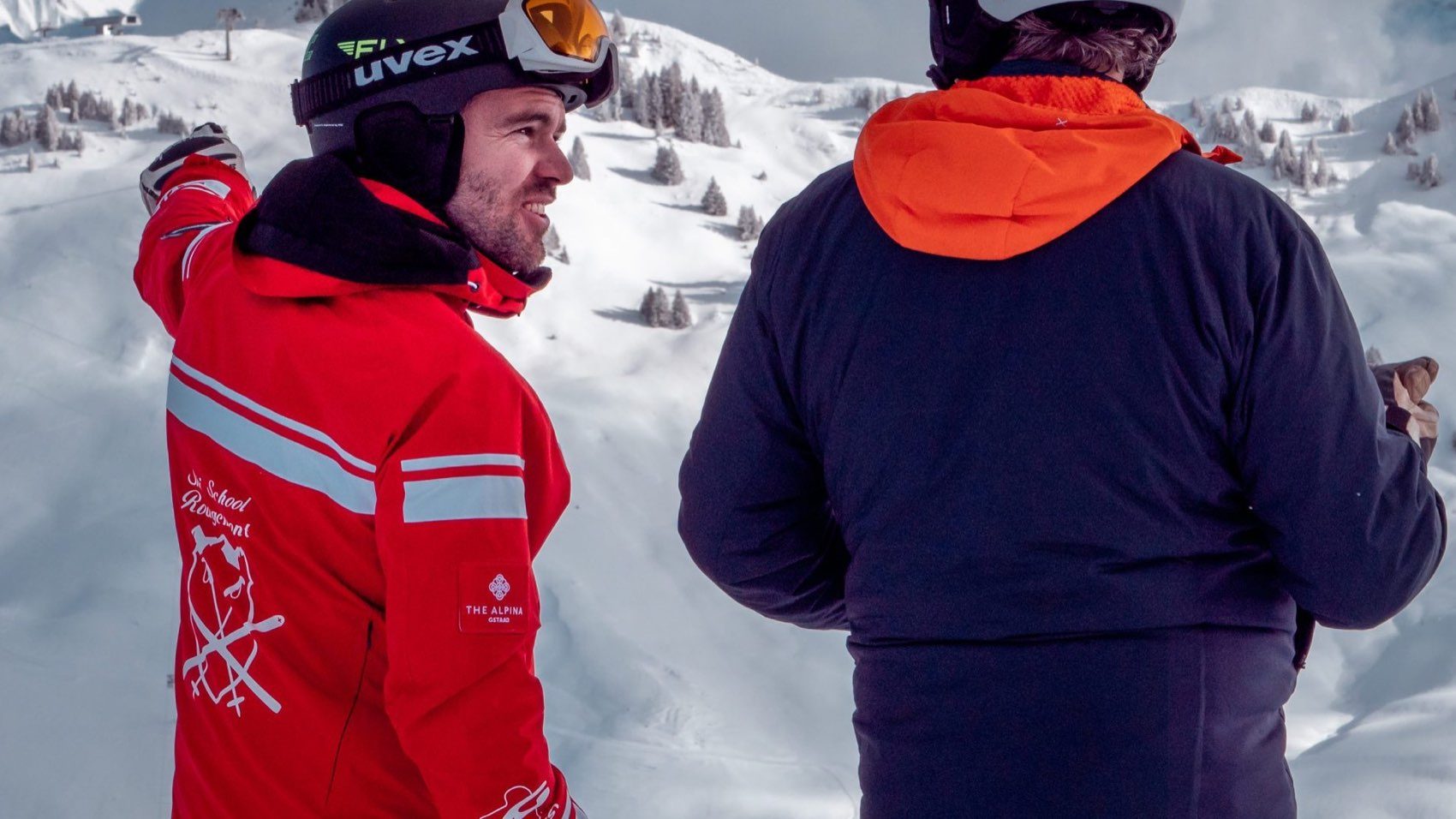 Private ski lessons in Gstaad: an instructor talking with a client above Rougemont