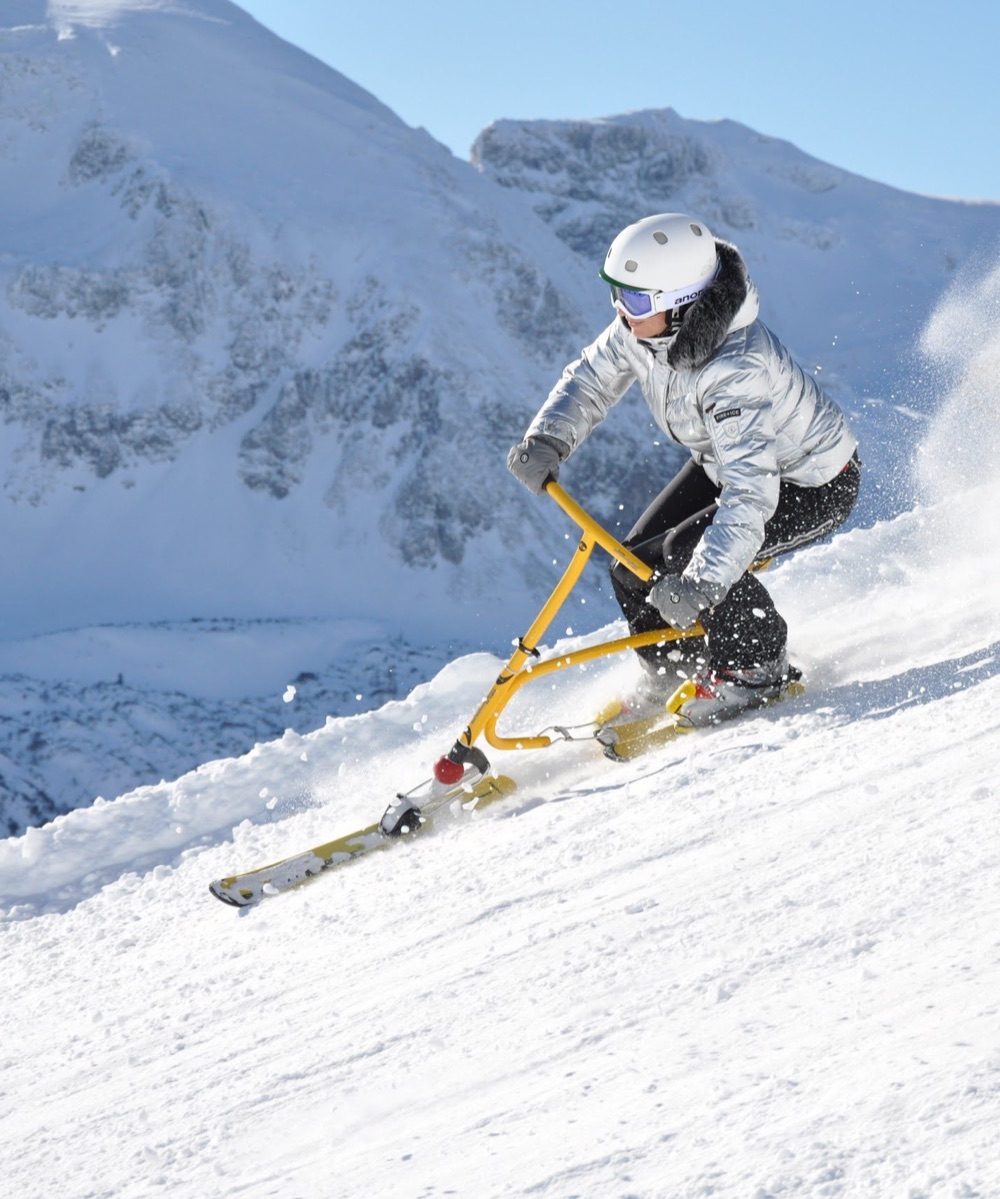 A snowbike rider on a wide empty piste above Rougemont, minutes from Gstaad